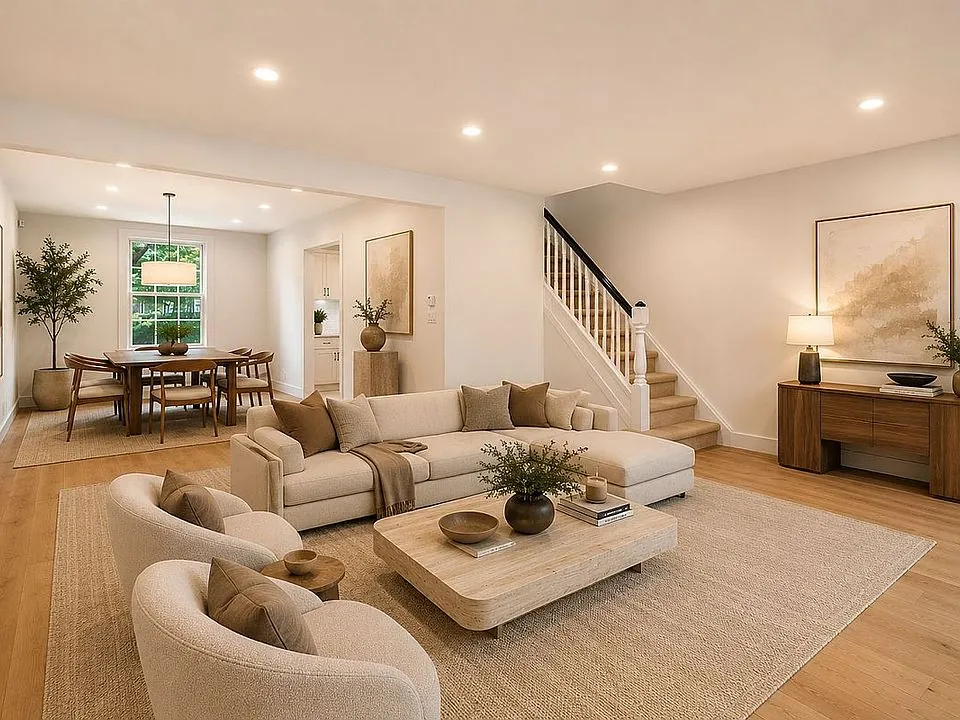 Living and dining room at 39-82 45th Street, with warm wood floors and cream furnishings